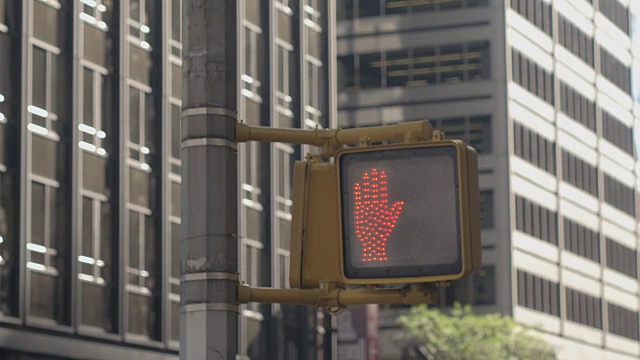 近景:行人高举红绿灯，用象形文字发信号，不走路视频素材
