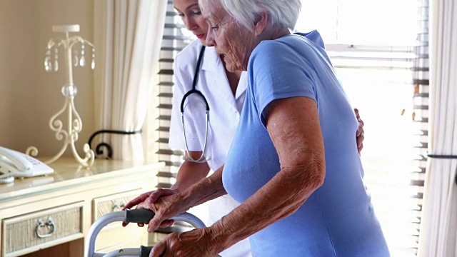 女医生帮助老年妇女用助行器走路视频素材