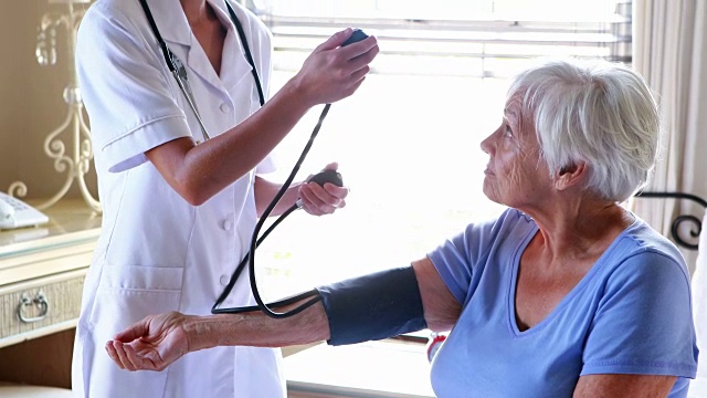 女医生在卧室给年长的女性检查血压视频素材