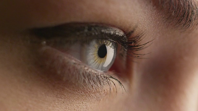 特写镜头的女人打开她的蓝色眼睛和聚焦她的视线。视频素材