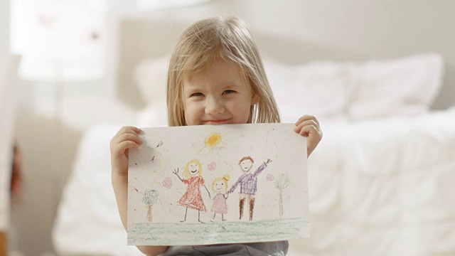 可爱的小女孩展示她的家庭图画。视频下载