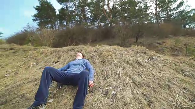 疲惫的年轻运动员喘着粗气，坐在大自然中休息视频下载