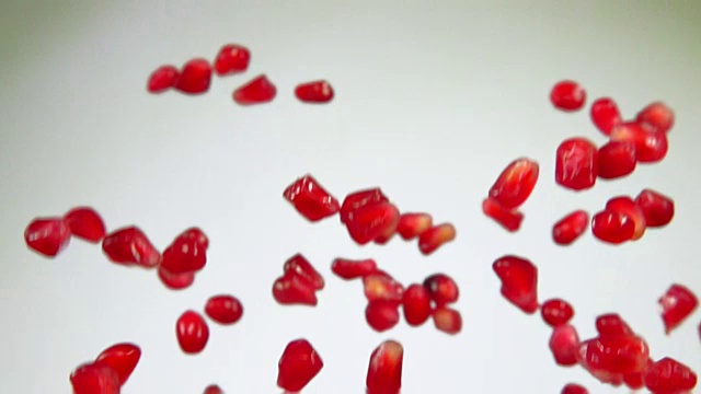 成熟的红石榴子在白色的背景上飞舞视频素材