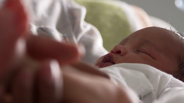 近距离的父母拥抱新生婴儿的儿子在托儿所视频素材