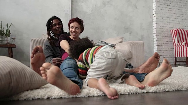 快乐的跨种族家庭赤脚坐在地板上视频素材