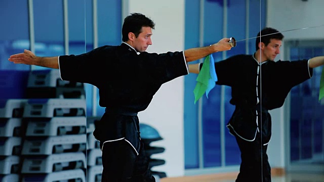 一个年轻人在体育馆里训练他的剑术视频下载