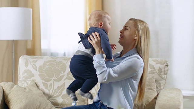 一个美丽的年轻母亲抱着她可爱的婴儿在她的怀抱长镜头。视频素材