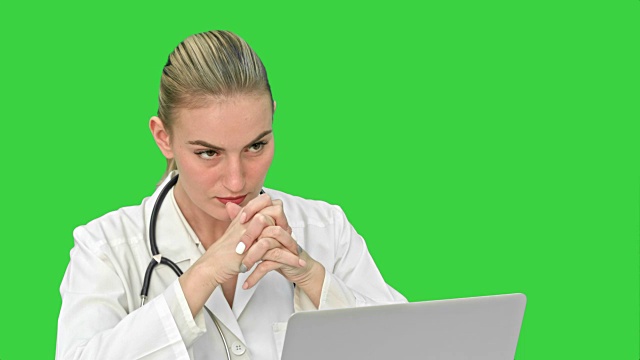 医生通过笔记本电脑在绿色屏幕上进行视频聊天，为病人提供在线咨询视频素材