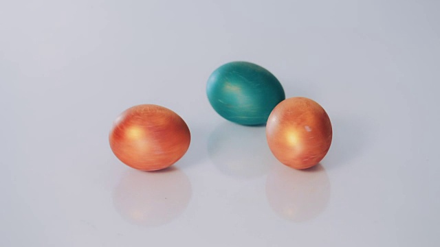 红色和绿色的复活节彩蛋在白色的背景上旋转，慢动作视频下载