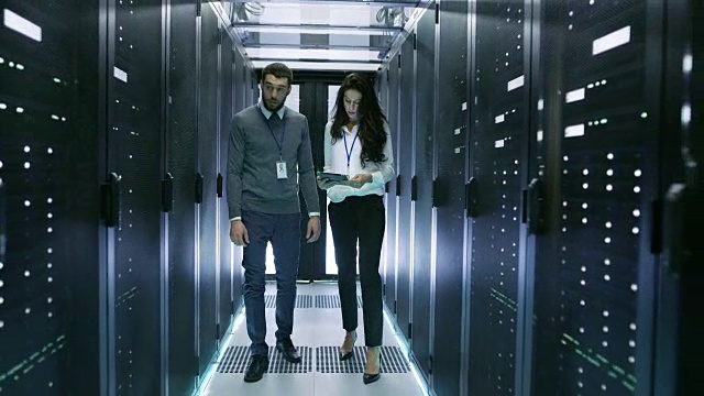 IT专家向他的女同事展示数据中心和一排排机架服务器。视频素材