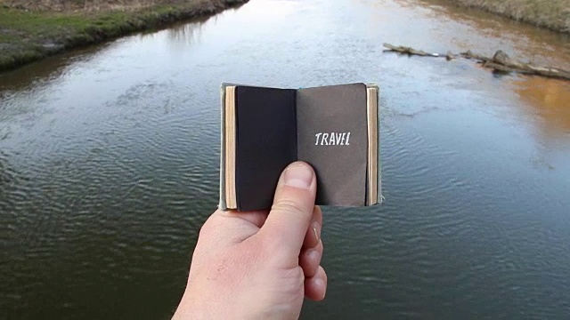 旅行的时候，旅行者手里拿着一本带文字的书视频下载