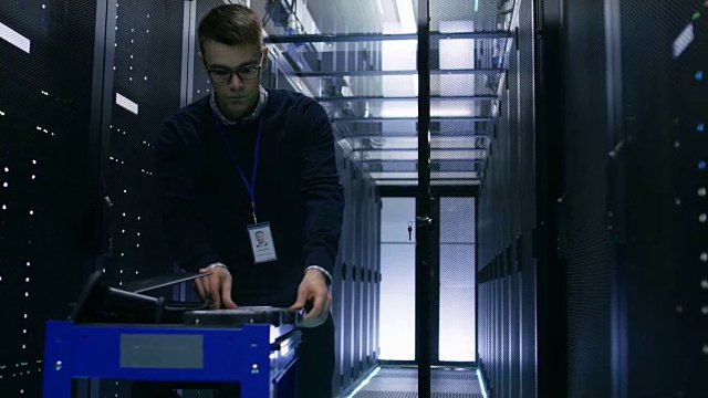服务器工程师更换机架服务器开放式机柜中的硬盘。他在大数据中心工作。视频素材