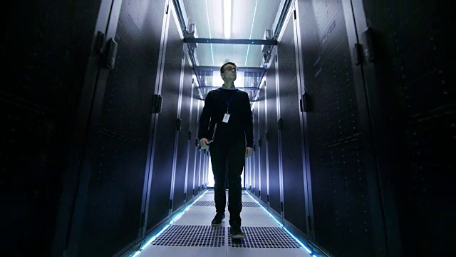 以下是IT工程师与一排排机架服务器穿过数据中心走廊的照片。视频素材