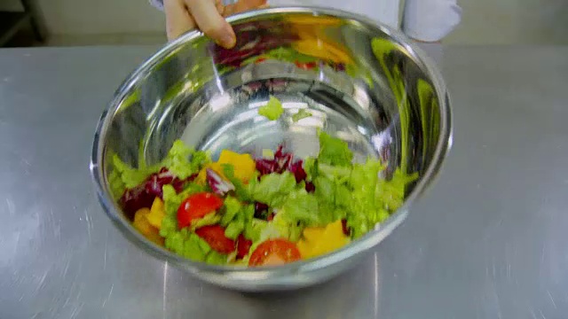 生菜掉进金属碗里。视频素材