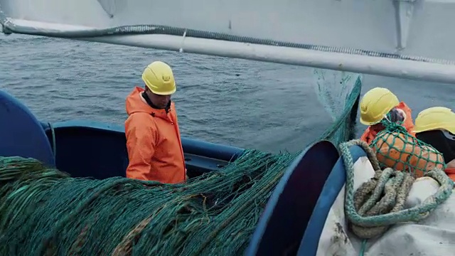 一队渔民在商业捕鱼期间解开拖网视频素材