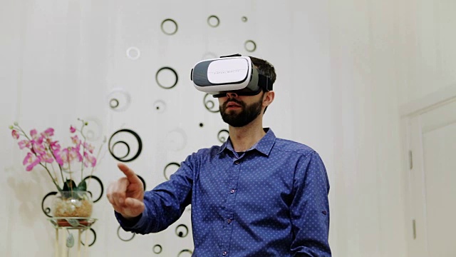 房间里的男人使用虚拟现实头盔视频购买