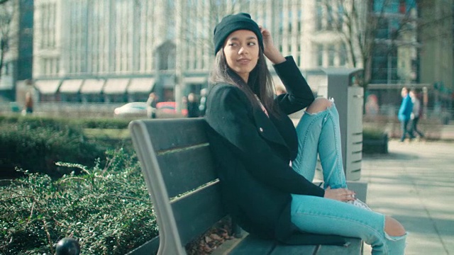 年轻美丽的非裔美国女人坐在长椅上。视频素材