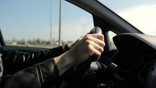 男人在城市里开车-方向盘和手的细节视频素材