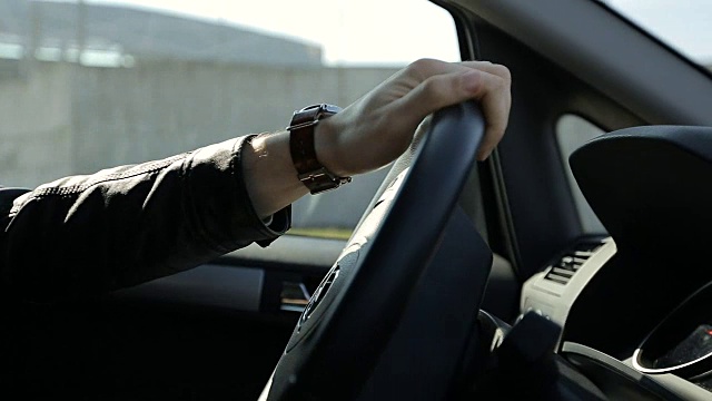 男人在城市里开车-方向盘和手的细节视频素材