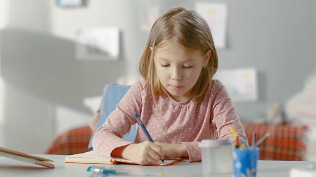 聪明的小女孩坐在房间里写日记。视频素材