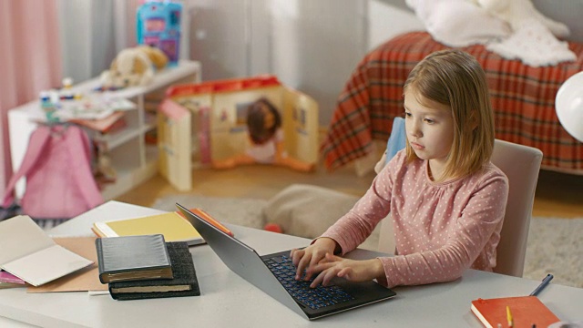 一个可爱的年轻女孩坐在她的房间里，用笔记本电脑打字。视频素材