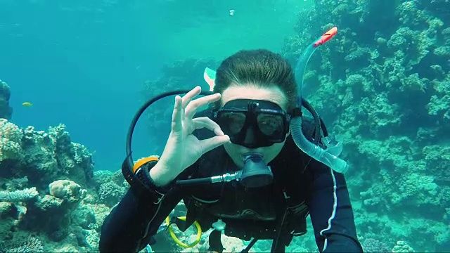 很棒的假期和在温暖的海洋中潜水。潜水员签下ok标志，然后在Self pin的视频中脱下自己视频素材