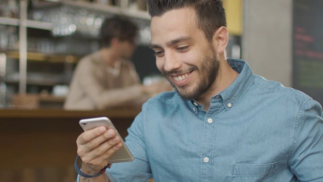 西班牙裔年轻人在舒适咖啡店使用手机。视频素材