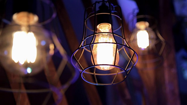 三盏装在金属格栅里的亮灯笼在蓝色的暮色中燃烧着视频素材