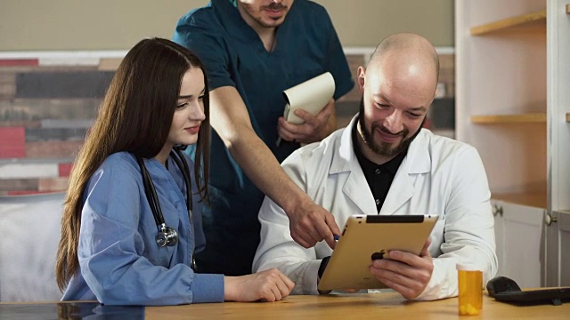 医疗保健:一组医生在诊所或医院用平板电脑讨论和检查x光。FHD FullHD视频素材