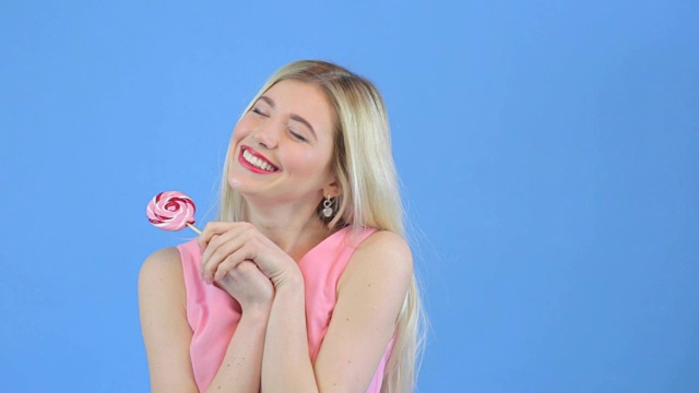 迷人的年轻女子高兴的礼物-彩色闪亮的棒棒糖视频素材