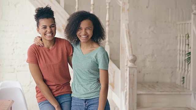 两个美丽的非洲裔美国女孩的肖像笑着看着相机。女人在家里从严肃的表情到大笑都会表现出情绪视频素材