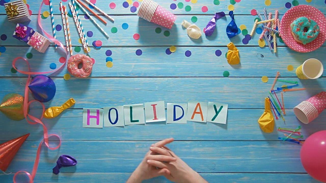 顶视图的人把“假日”放在桌子上，用生日装饰视频下载