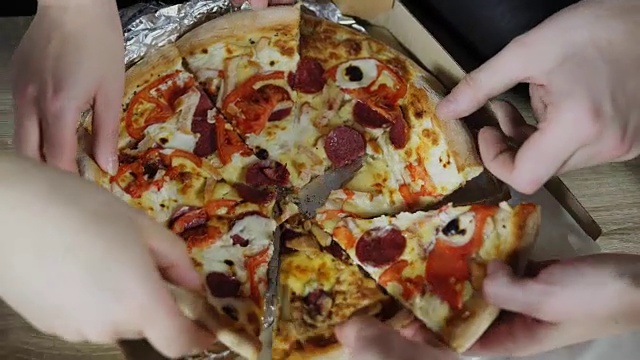 特写的人的手拿片披萨从食品外卖打开的盒子。美味服务办公室。关注手部的变化。在4 k拍摄视频素材