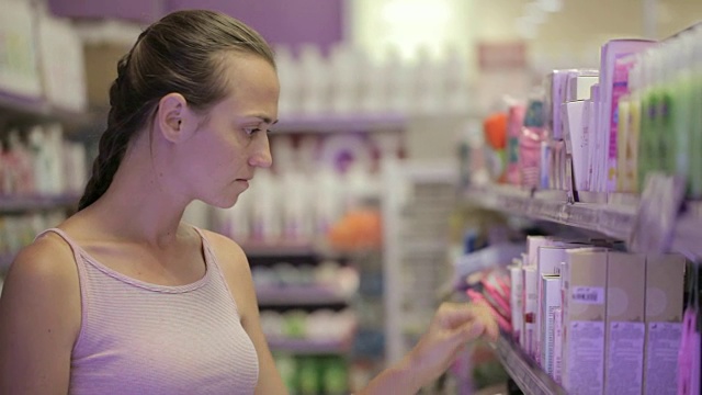 有魅力的女人在超市的化妆品区看身体护理产品视频素材