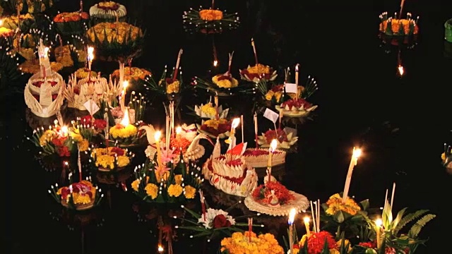 在Loi Khrathong庆典上，燃烧的蜡烛漂浮在水上。视频下载