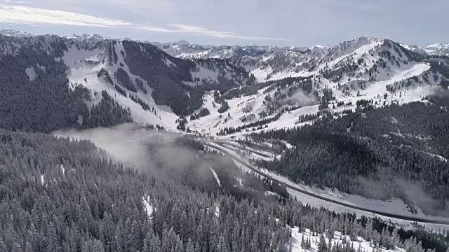 空中Flyback在史蒂文斯帕斯滑雪度假村与喀斯喀特山脉的背景视频素材