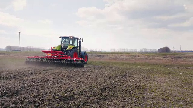 斯坦尼康飞周围射击:拖拉机犁土地上的田地。农业是现代视频下载