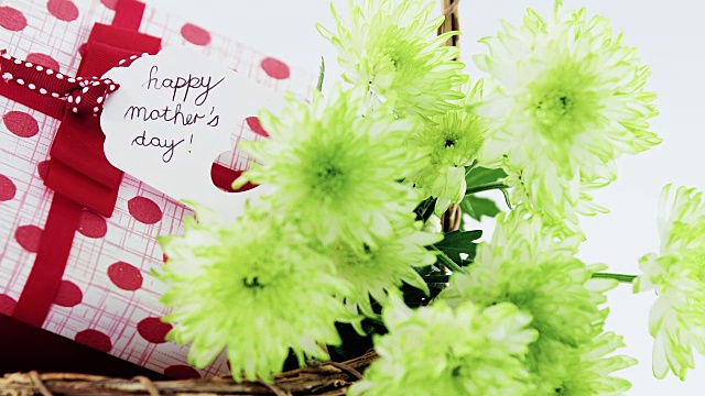 礼物盒和一束黄色花柳条篮子与快乐的母亲节标签视频下载