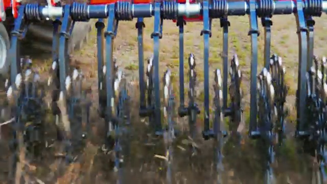斯坦尼康跟踪镜头:一个特写的一部分农业机器是一个旋转的中耕机。处理地面以清除杂草和防止土壤干燥视频素材