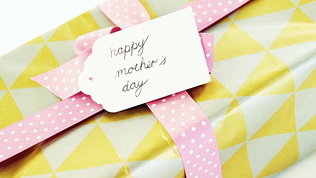 礼物盒与快乐的母亲节标签在白色的背景视频下载