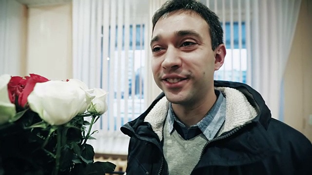 快乐的男人捧着一束玫瑰。视频素材