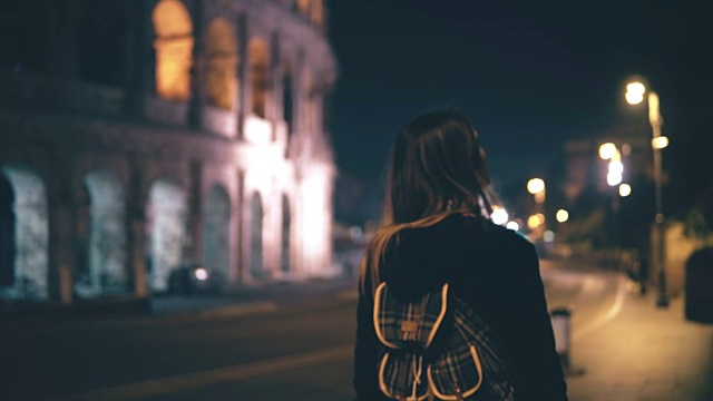 年轻迷人的女人深夜独自走在意大利罗马。女孩穿过罗马斗兽场附近的市中心视频素材