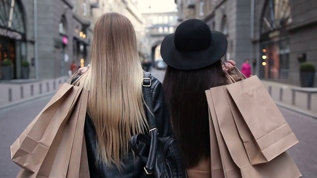 后视图两个行走的妇女与购物袋视频下载