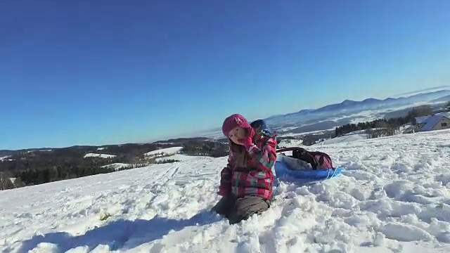 在山上和孩子的雪地上追踪移动视频下载