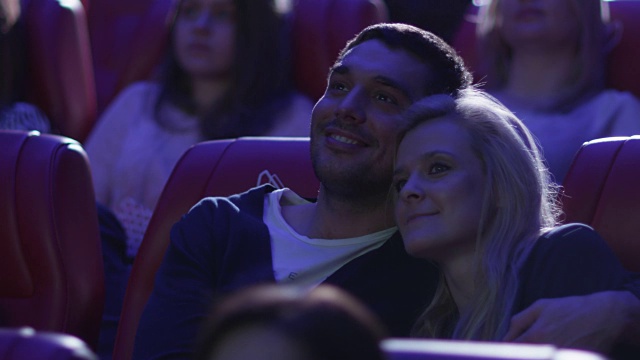 一对幸福浪漫的年轻夫妇正在电影院看电影。视频素材
