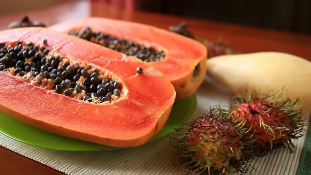 餐桌上有异国情调的热带水果。泰国的水果。番木瓜，切成两半。特写镜头视频下载