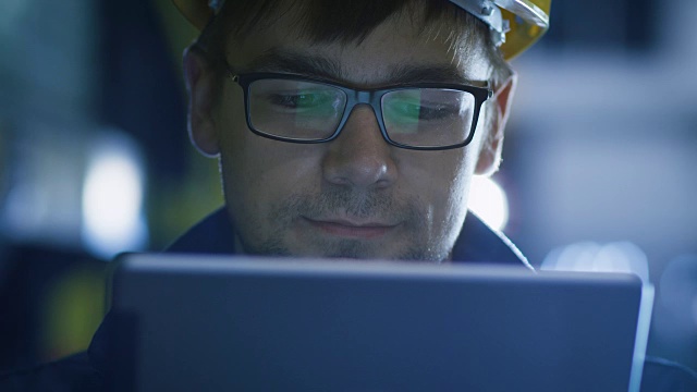 眼镜和安全帽技师在工业环境中使用平板电脑。屏幕眼镜的反光视频素材
