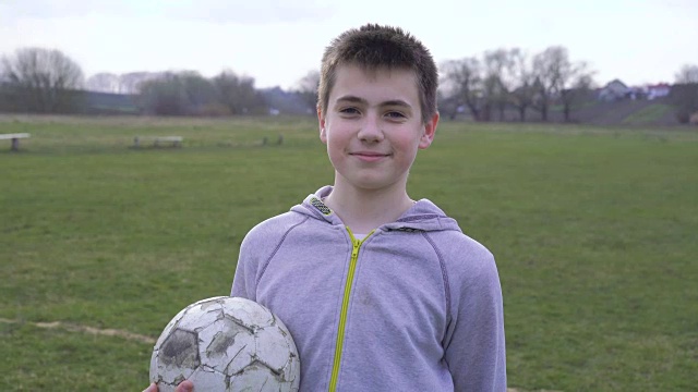 满面笑容的男孩手拿球在体育场的肖像全高清视频下载