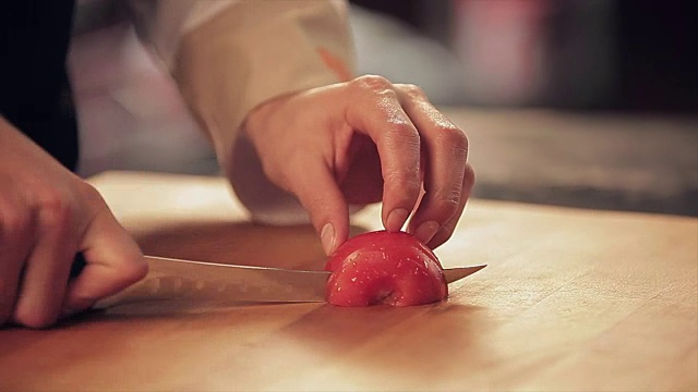 厨师将番茄切在砧板上视频素材