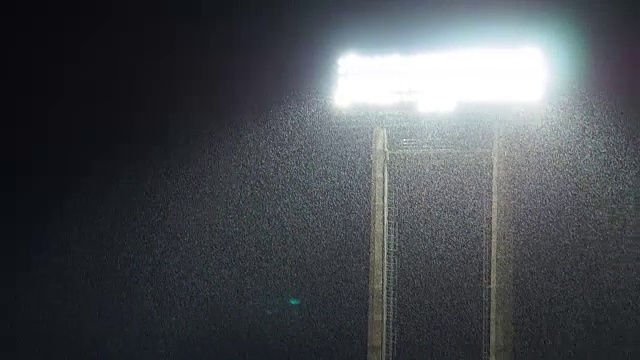 在足球比赛间隙下大雨的时候，闪电体育场的灯光在夜间闪烁视频素材